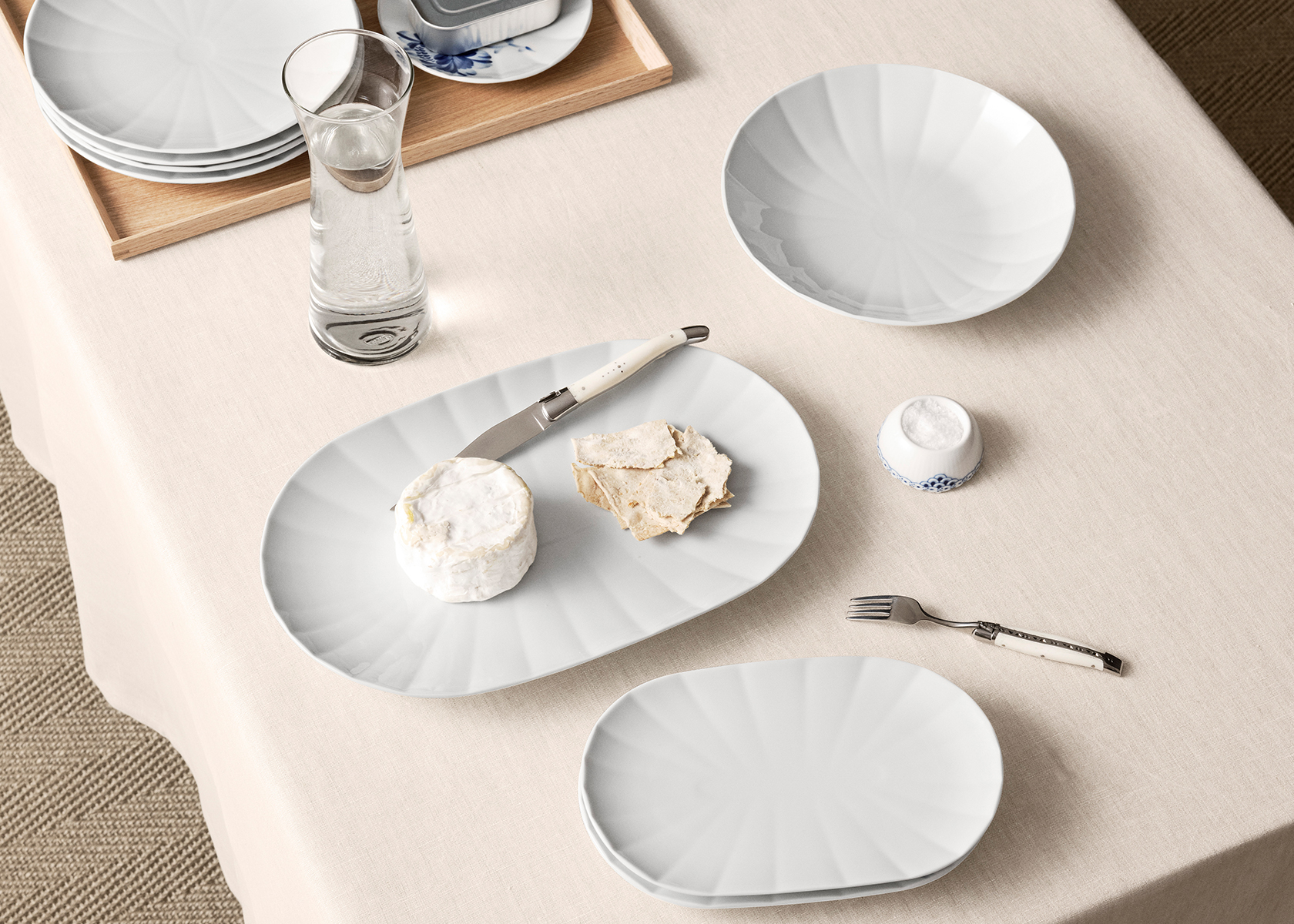 to serveringsfade fra Hvid Facet står på et lyst bord. På det ene fad ligger lidt ost